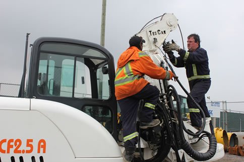 Technicians working on drilling equipment from a service truck